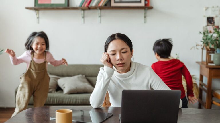Jeune mère débordée, épuisée, essayant de tout gérer à la maison avec ses enfants autour — illustration de la charge mentale