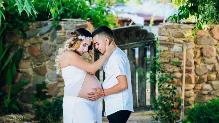 Futur papa, main posée sur le ventre arrondi de sa compagne enceinte