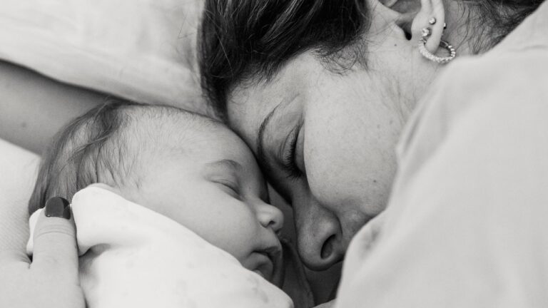 Maman et bébé assoupis ensemble sur un lit