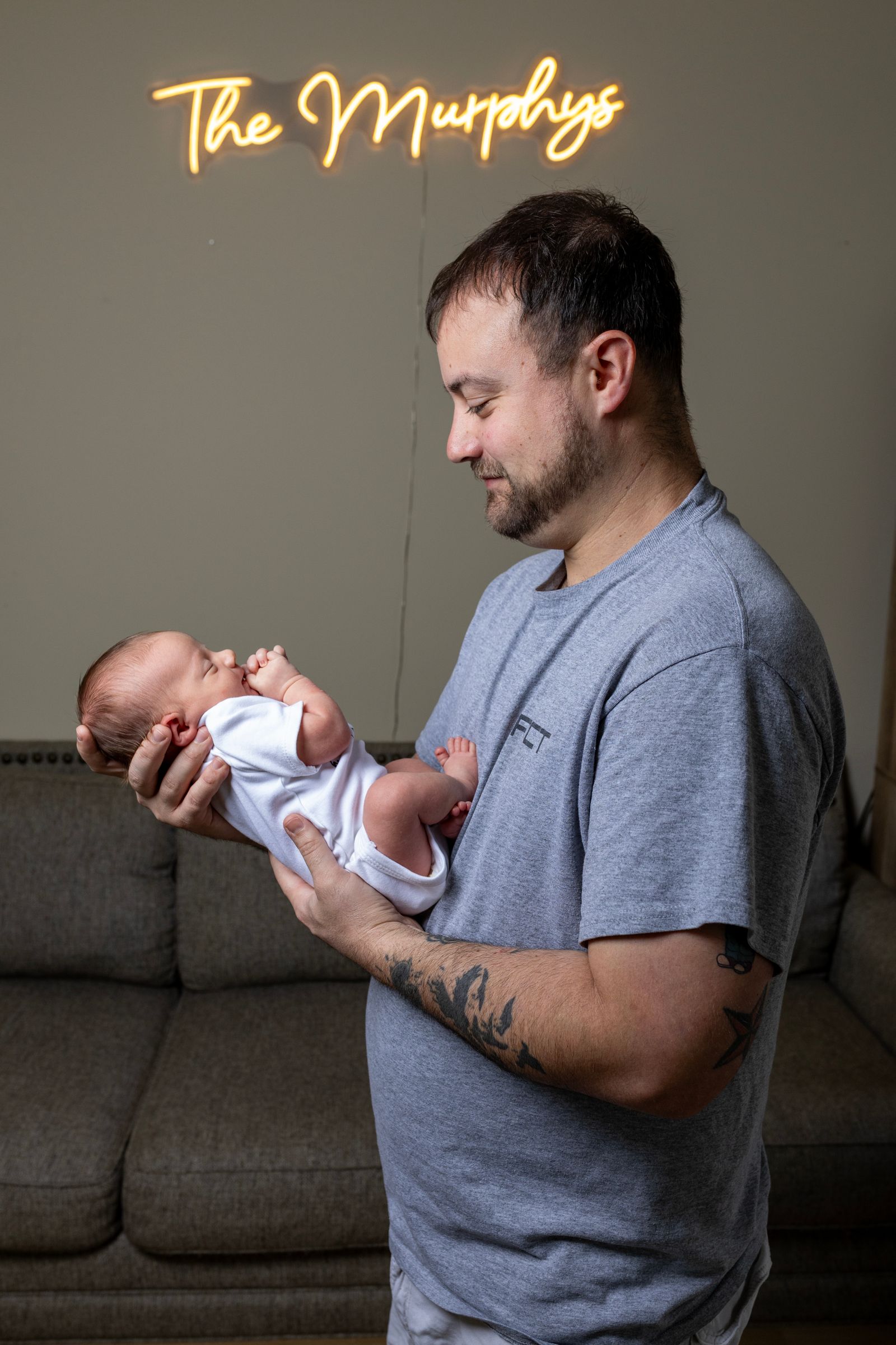 Papa tenant son nouveau-né dans un salon chaleureux pendant son congé de naissance